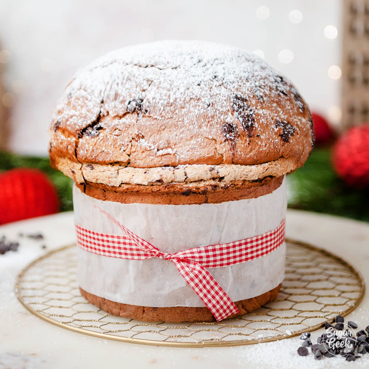 homemade panettone with parchment paper and a decorative ribbon wrapped around the middle