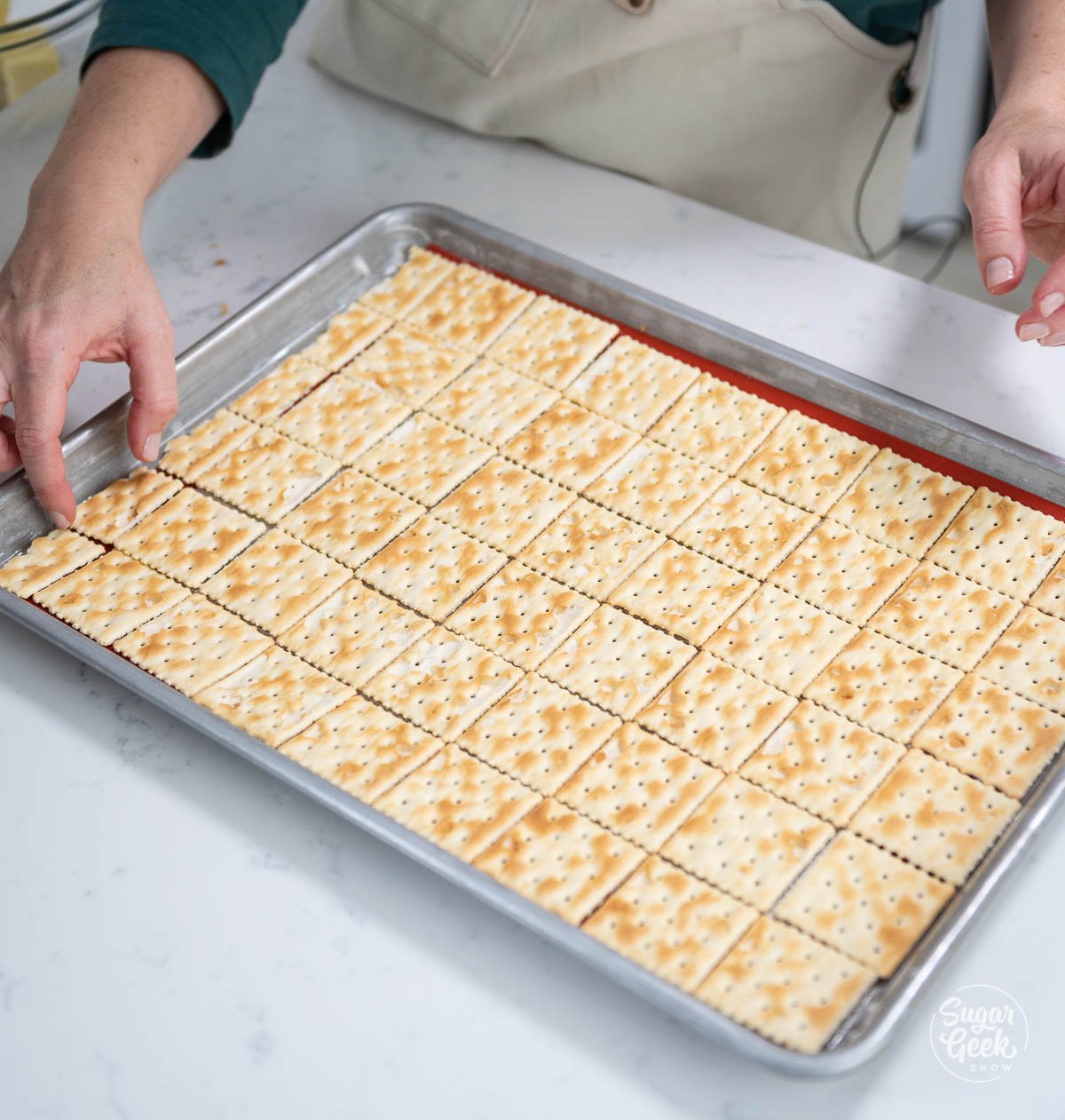 placing saltine crackers on a sheet pan
