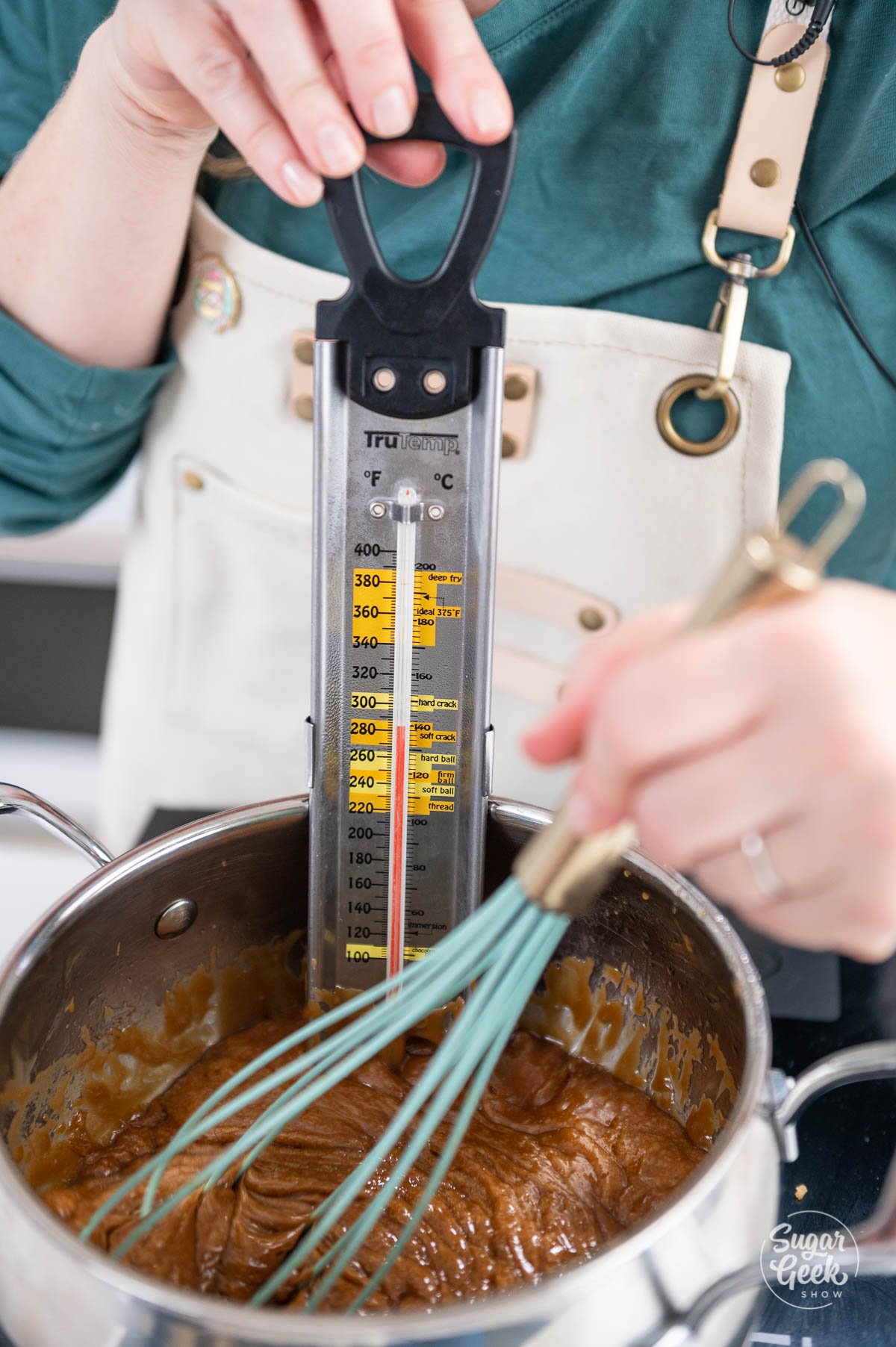 closeup of candy thermometer in a pot of toffee