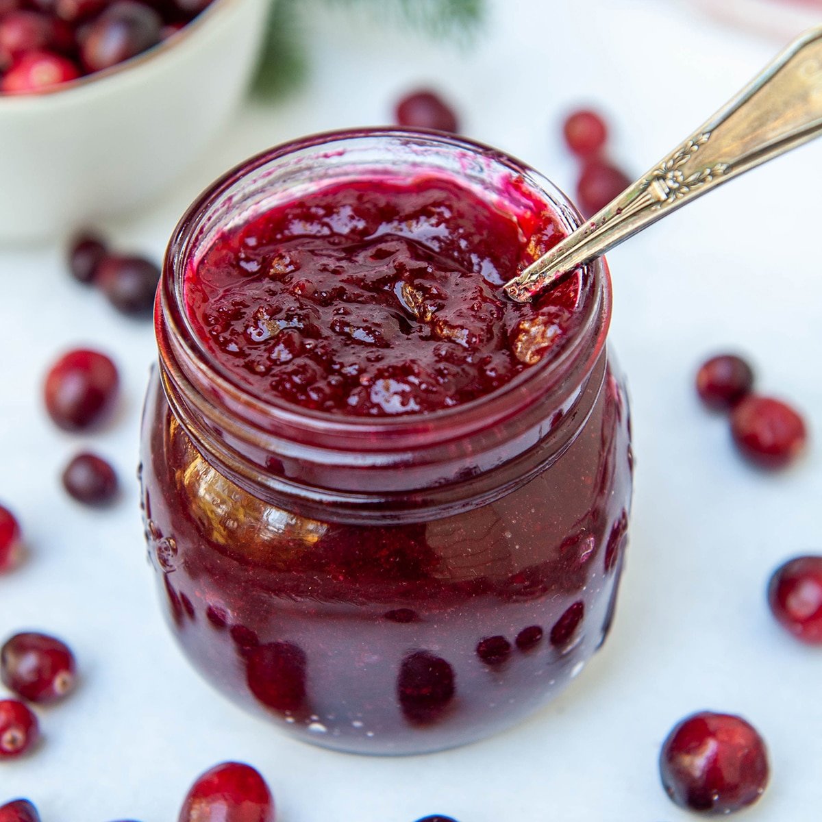 close up of cranberry filling in a jar with a spoon