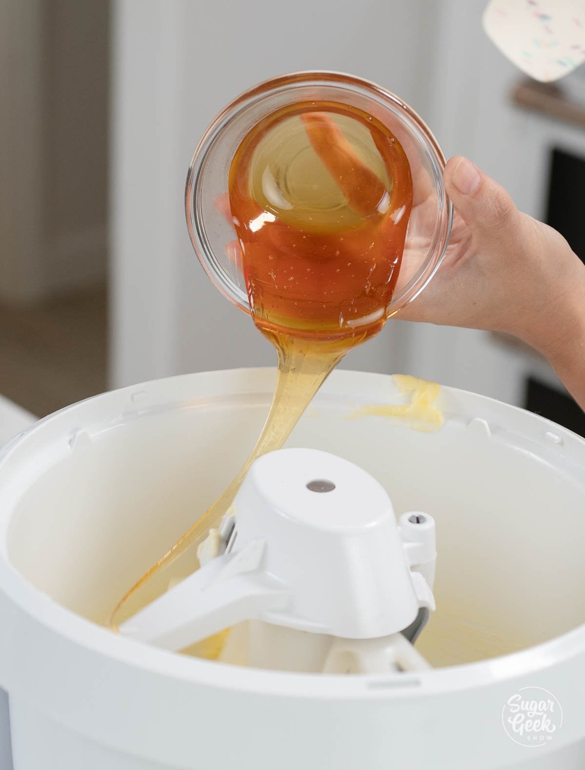 pouring honey into the bowl of a stand mixer