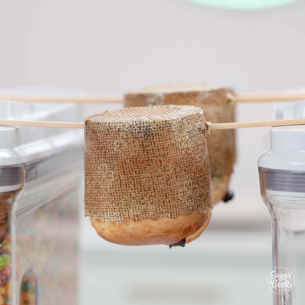 Panettone being hung upside down by skewers