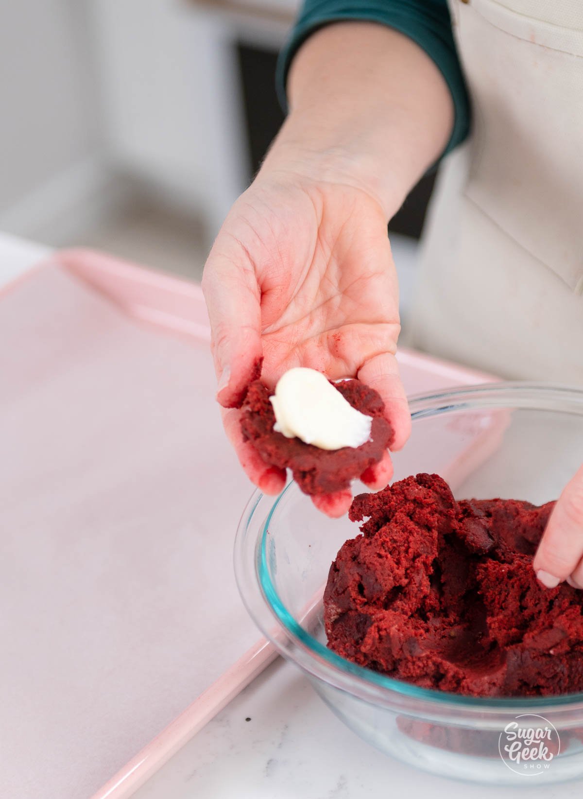 placing cream cheese onto red velvet cookie dough