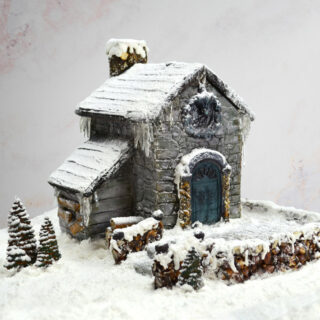 Gingerbread house with powdered sugar snow, isomalt icicles, edible trees and fence