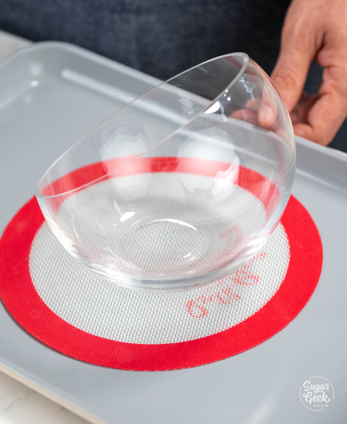 glass dish on top of a non-slip mat on a baking sheet