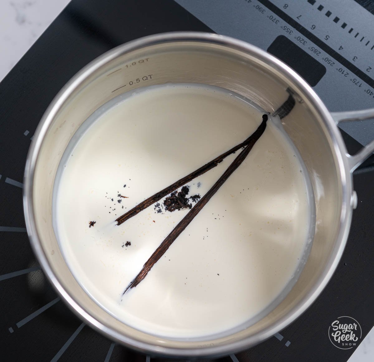 vanilla bean pod and seeds sauce pan on top of cream