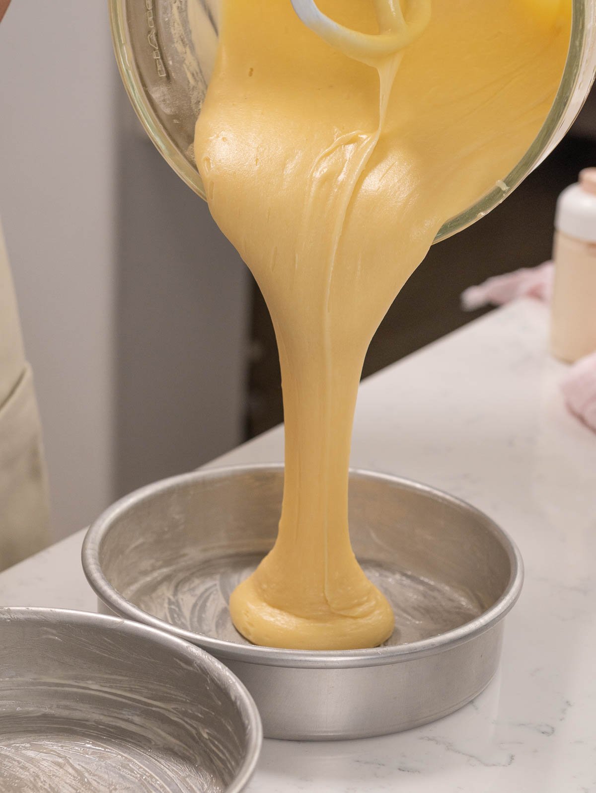 pouring cake batter into the cake pan