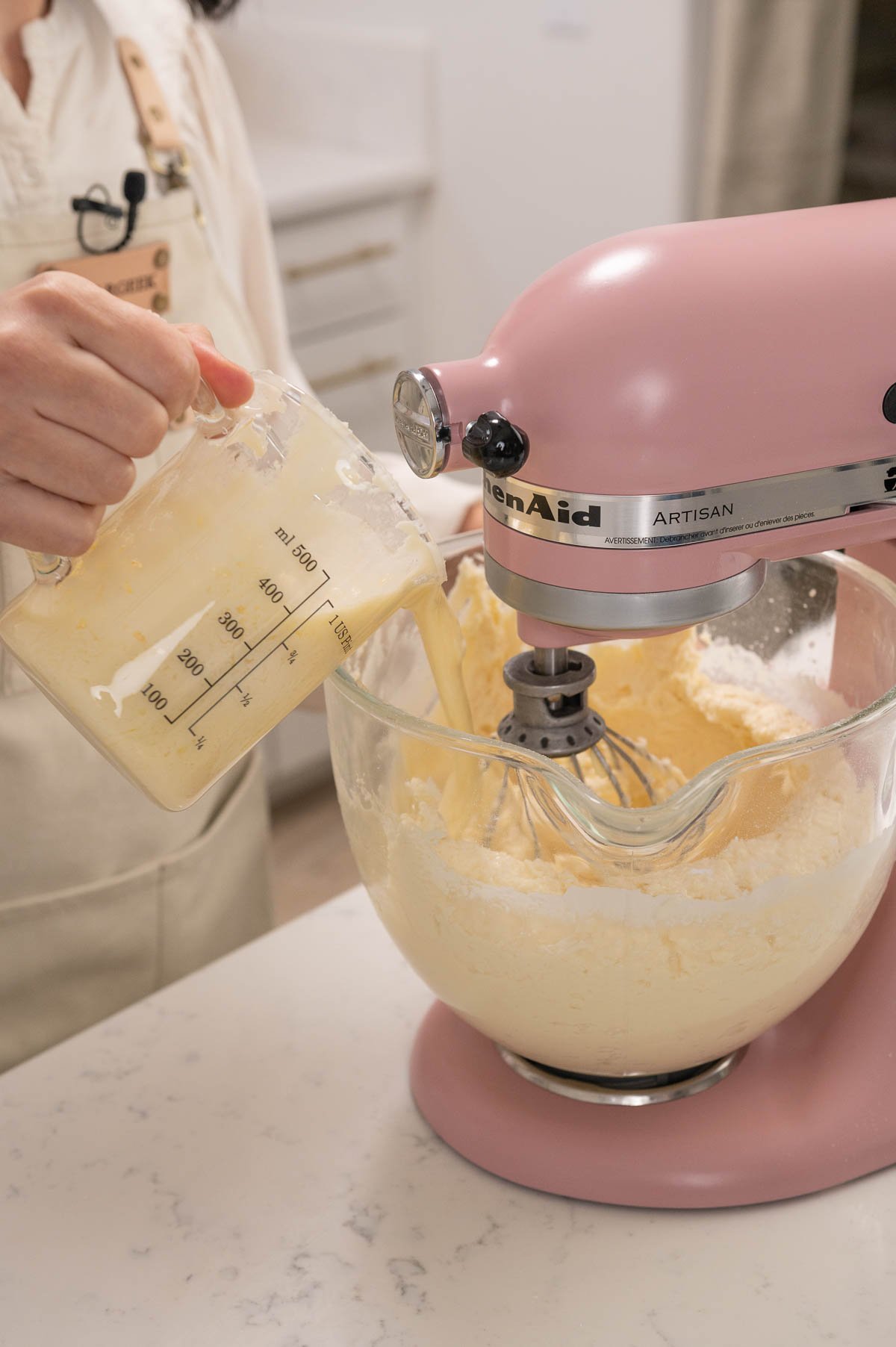 pouring melted buttercream back into the mixer