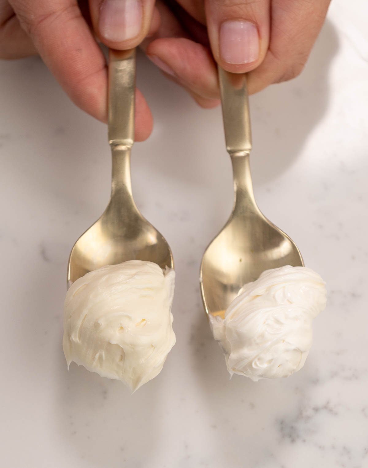 side by side spoons with buttercreams to show the pure white vs regular. 