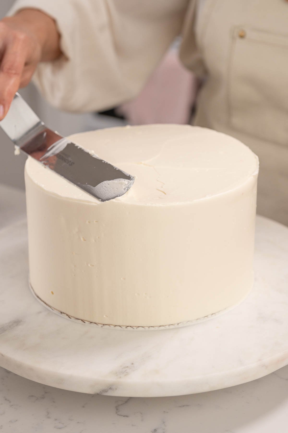 final layer of buttercream on vanilla cake