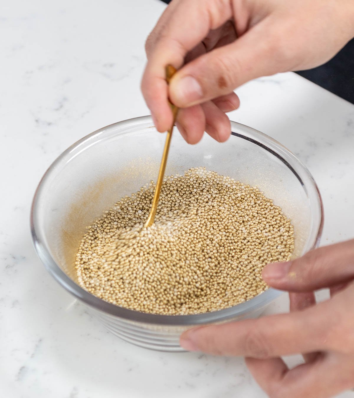 hand mixing edible gold dust in sprinkles