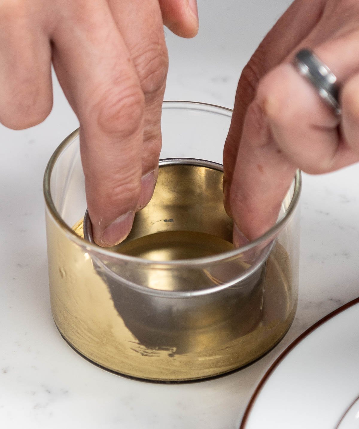 hand placing ring inside of edible gold