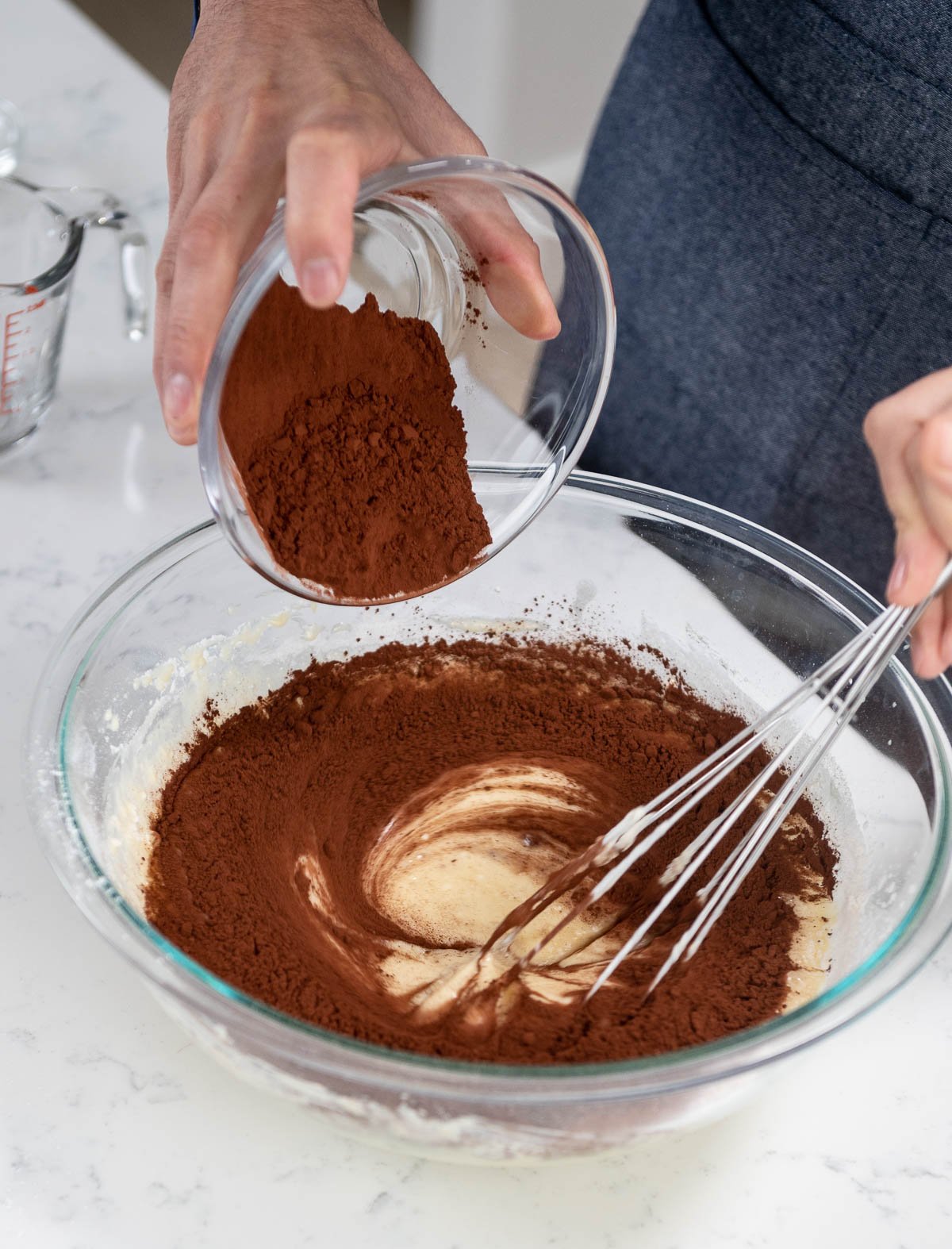 pouring ingredient into mixing bowl while whisking