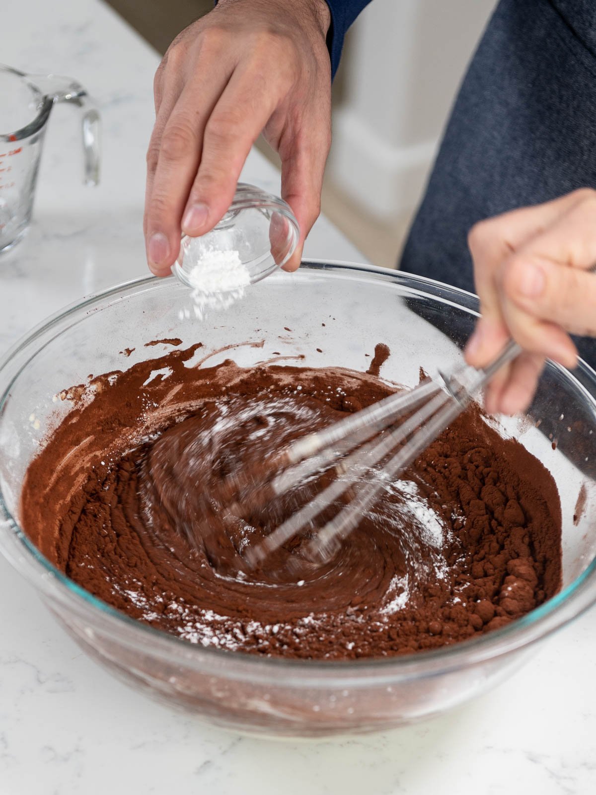 pouring ingredient into mixing bowl while whisking