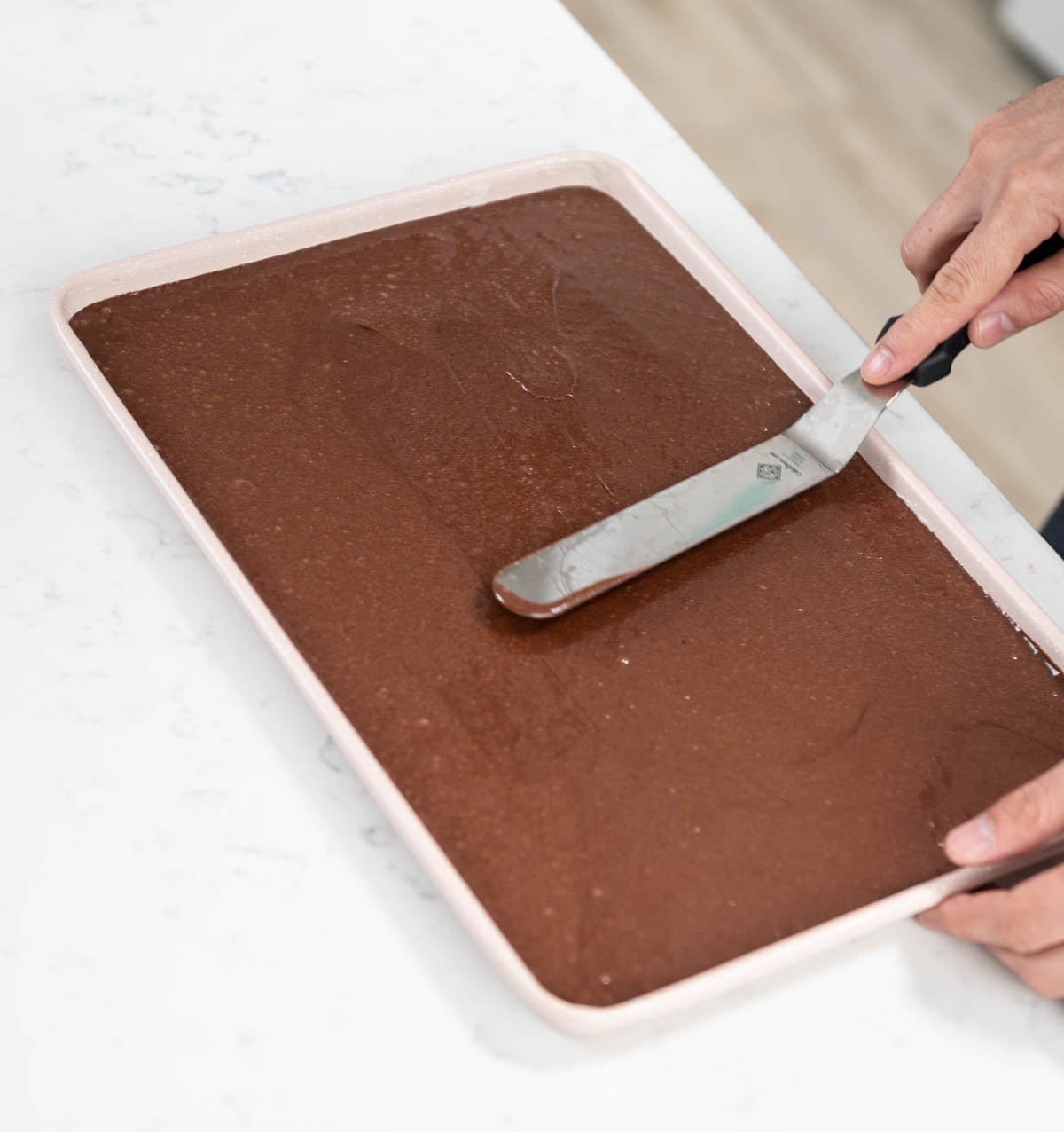 smoothing out cake batter with a spatula