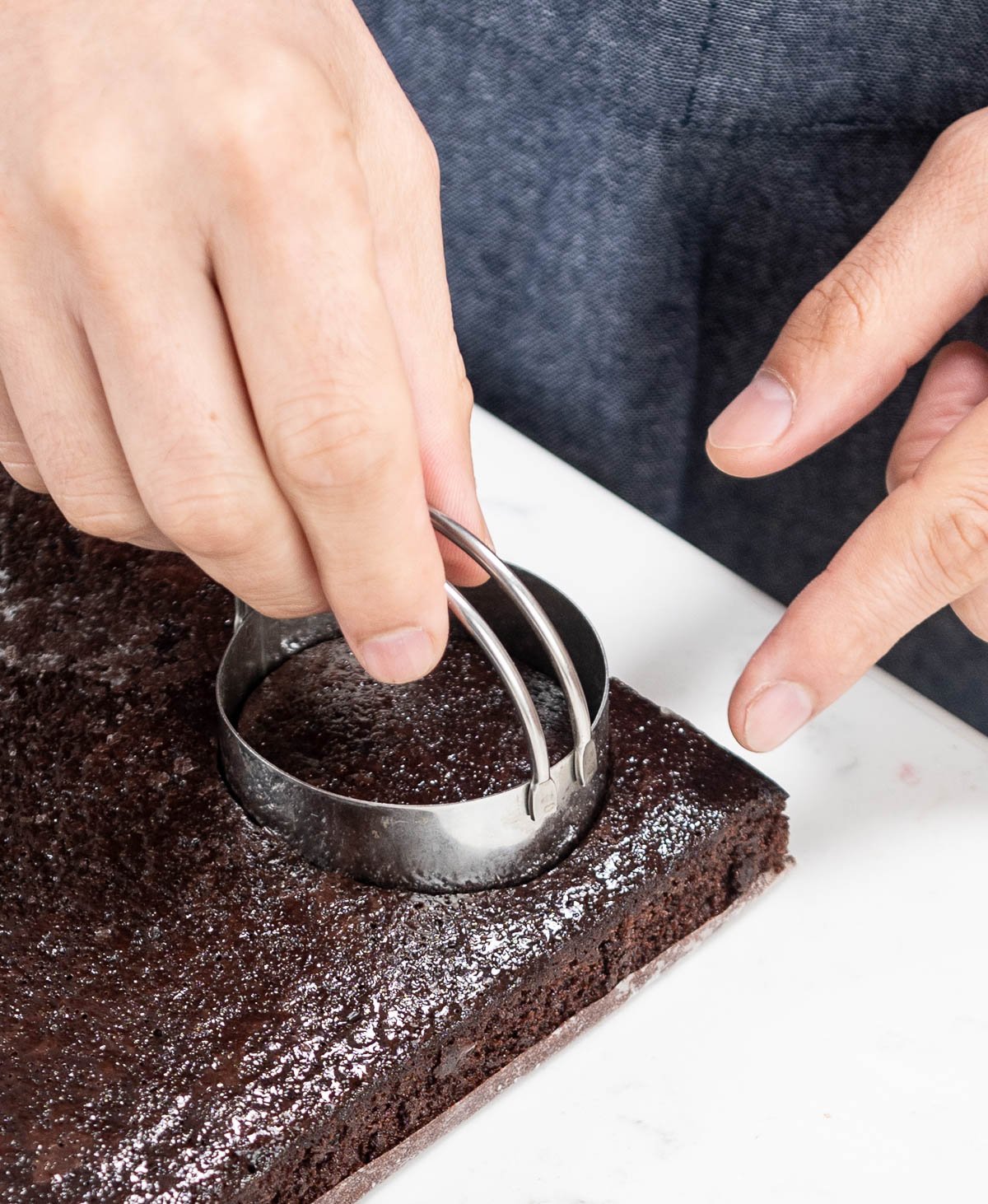 hand placing cake ring into cake