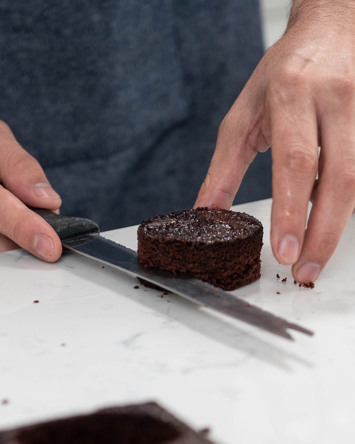 hand trimming chocolate cake