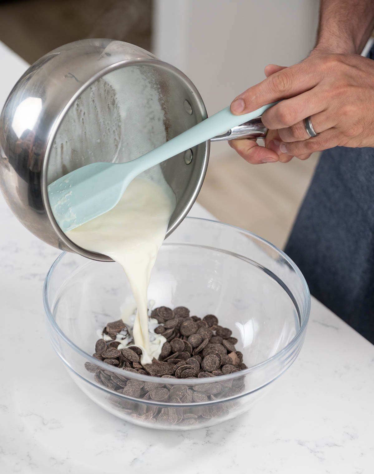 pouring cream over chocolate in a mixing bowl