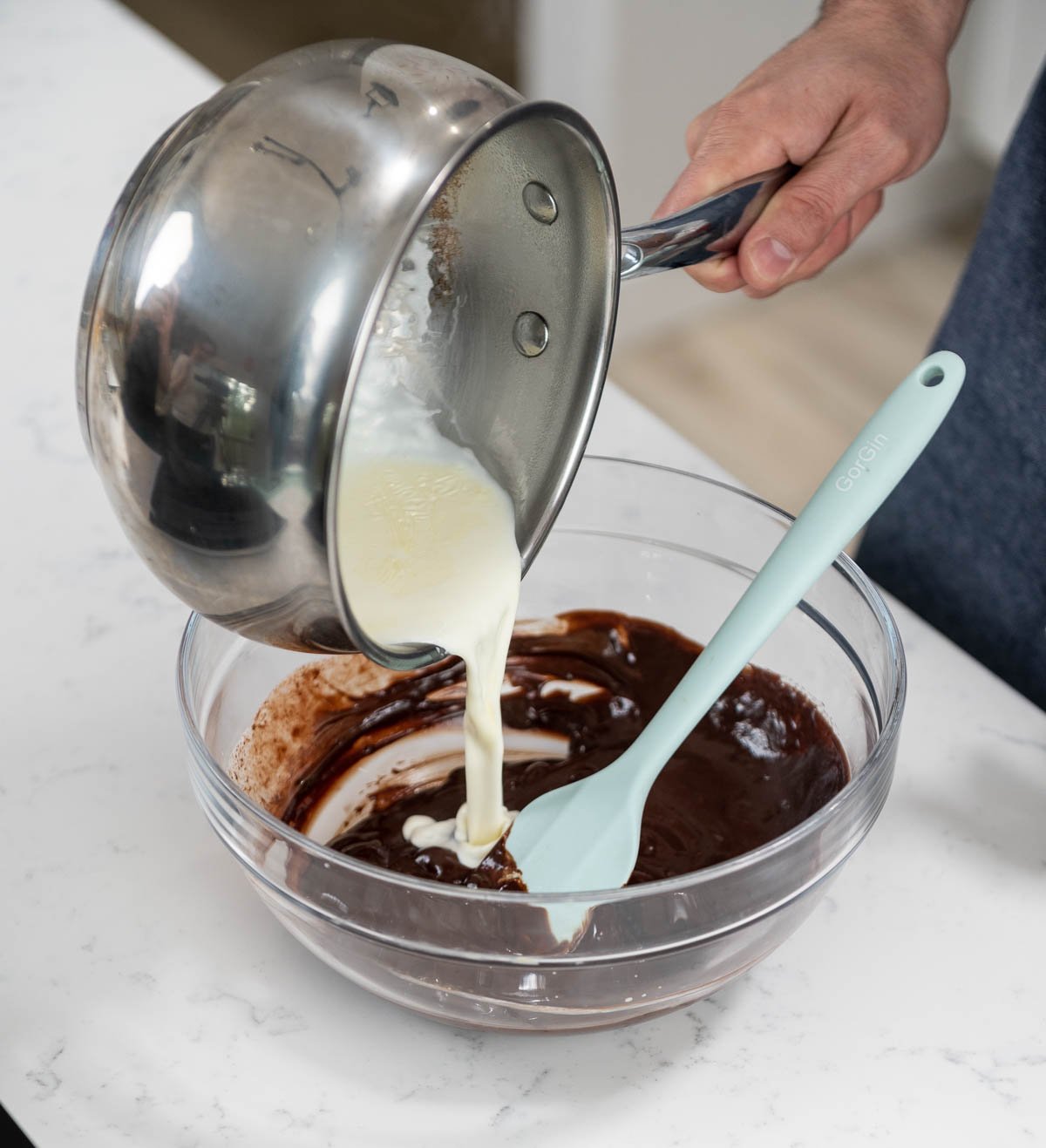 pouring saucepan ingredients into mixing bowl