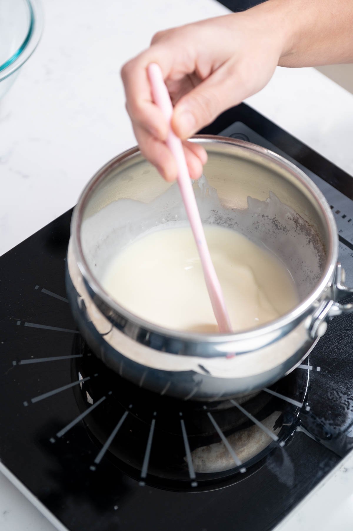 hand mixing with spatula inside saucepan