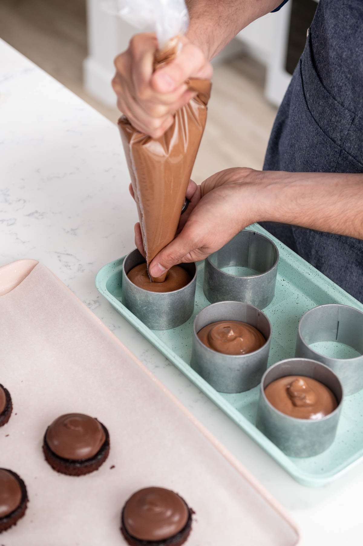 hand piping mousse into entremet pans