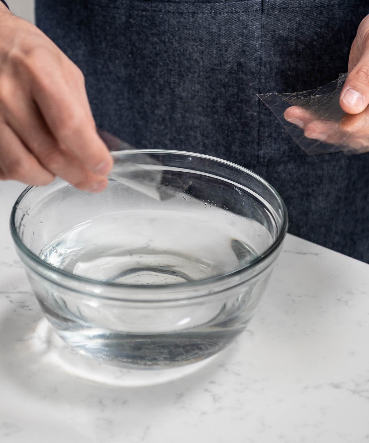 holding gelatin sheets above bowl of water