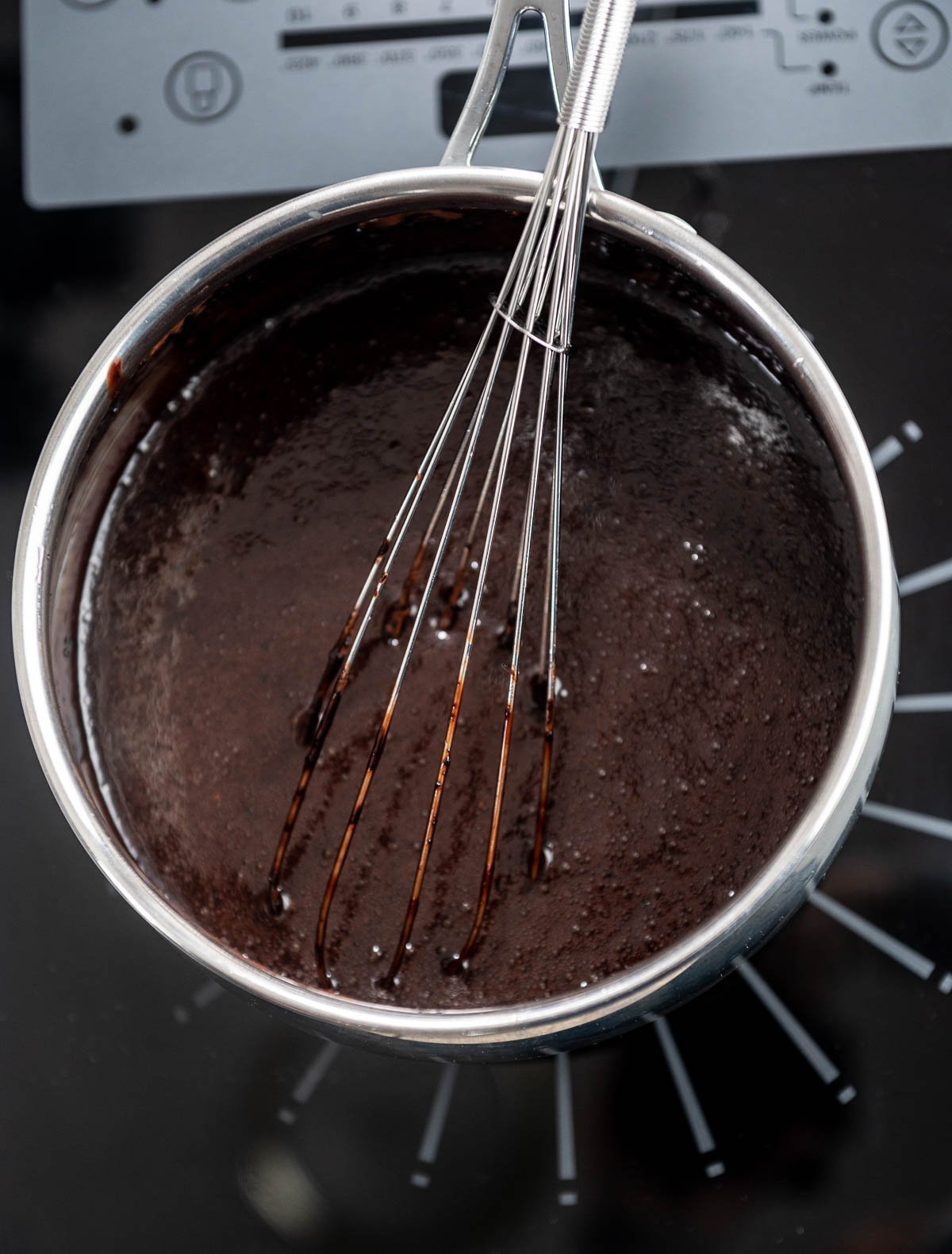 whisk inside of saucepan filled with chocolate