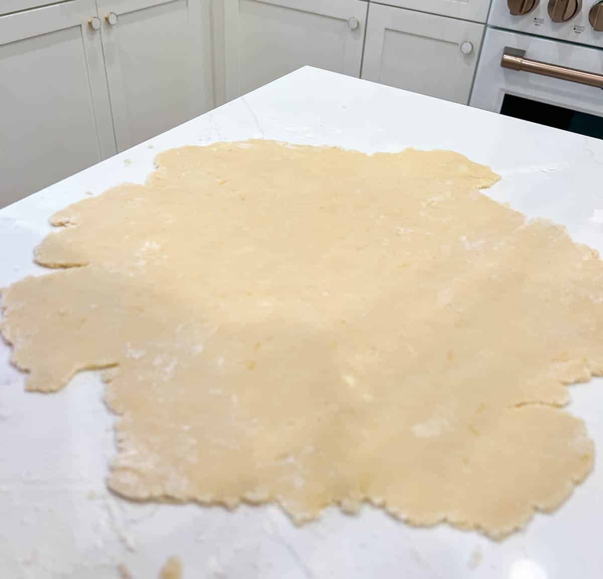 tart dough rolled out on a kitchen counter