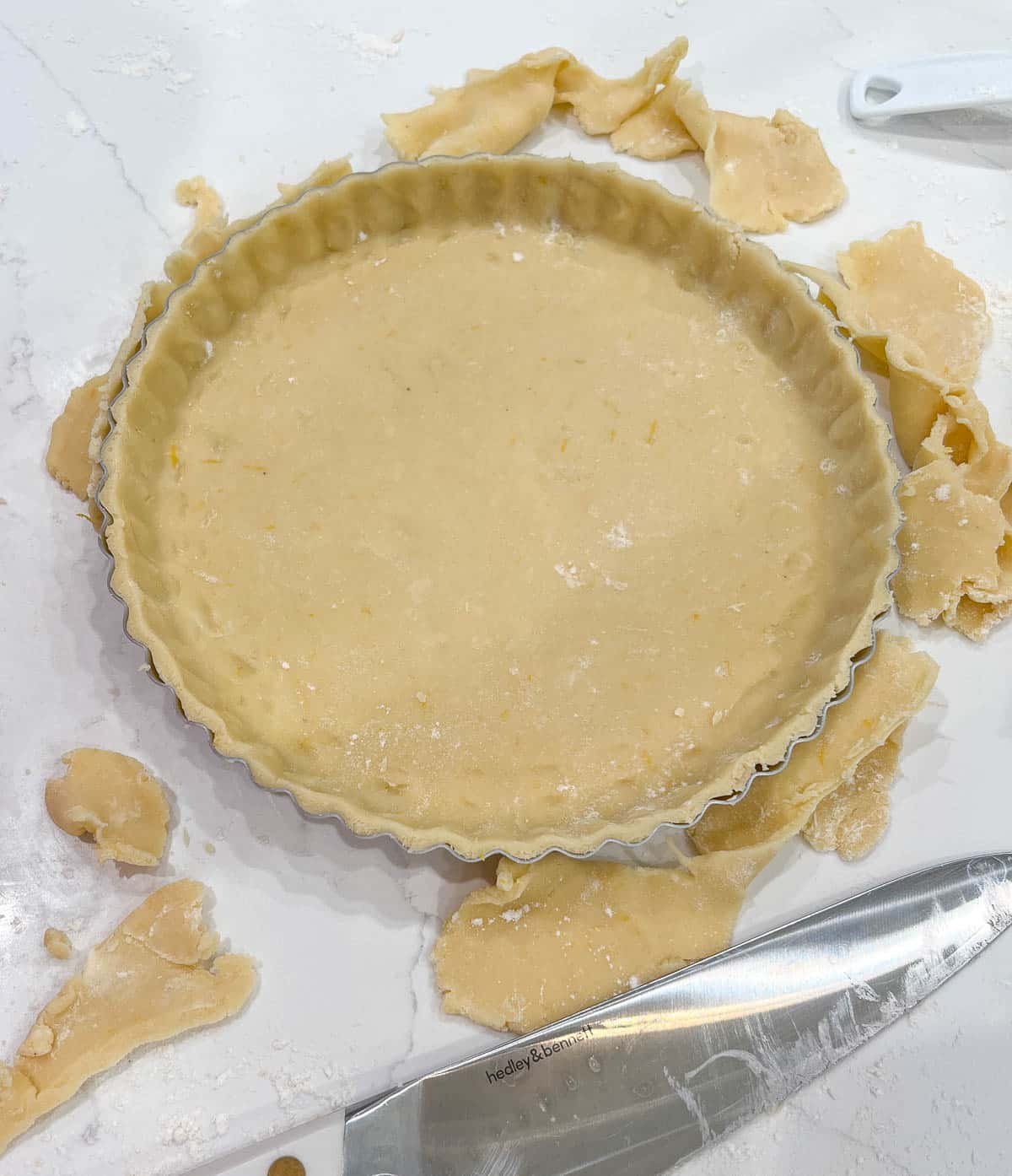 tart dough in a tart pan with leftovers trimmed off