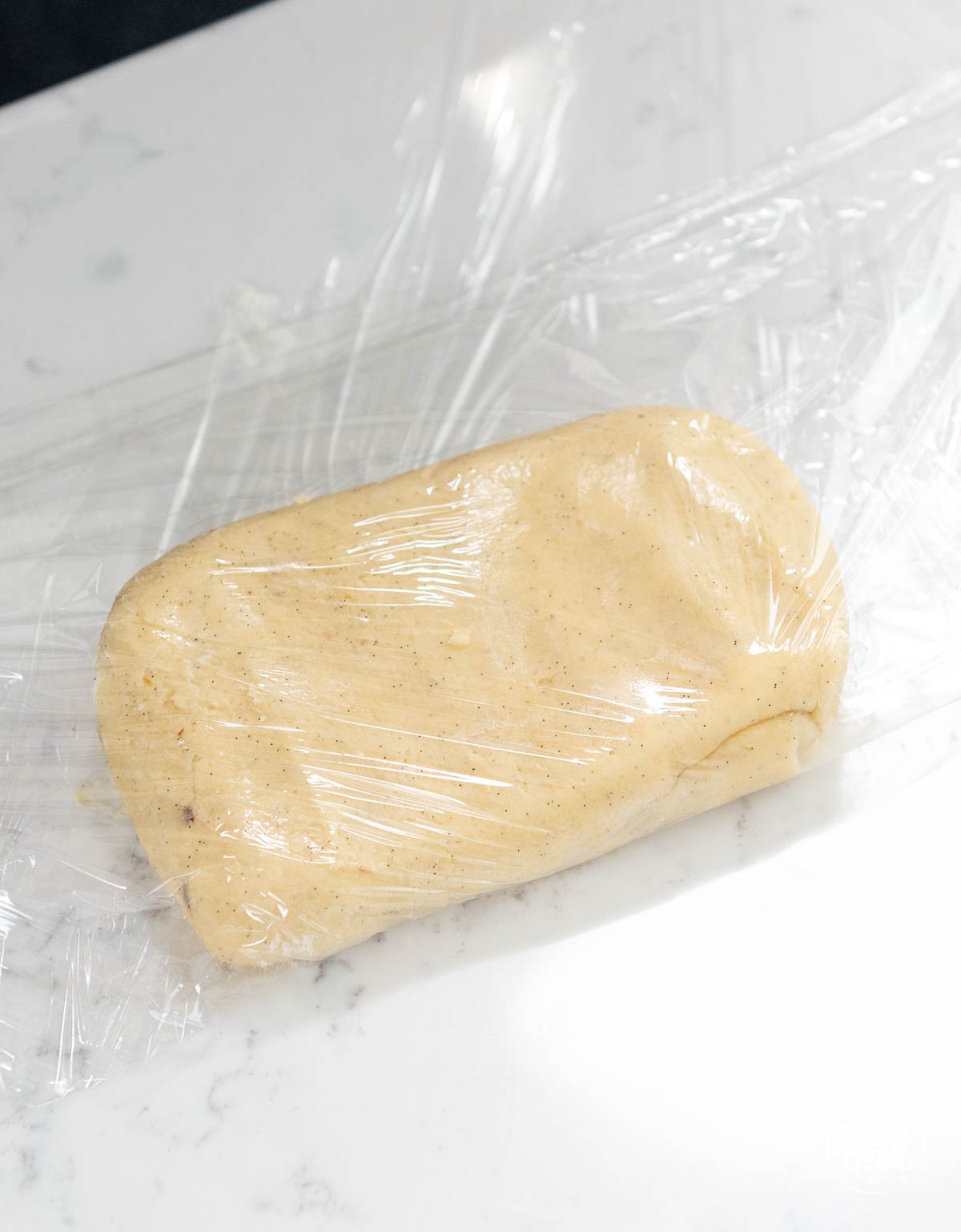 dough in a rectangle shape covered in plastic wrap