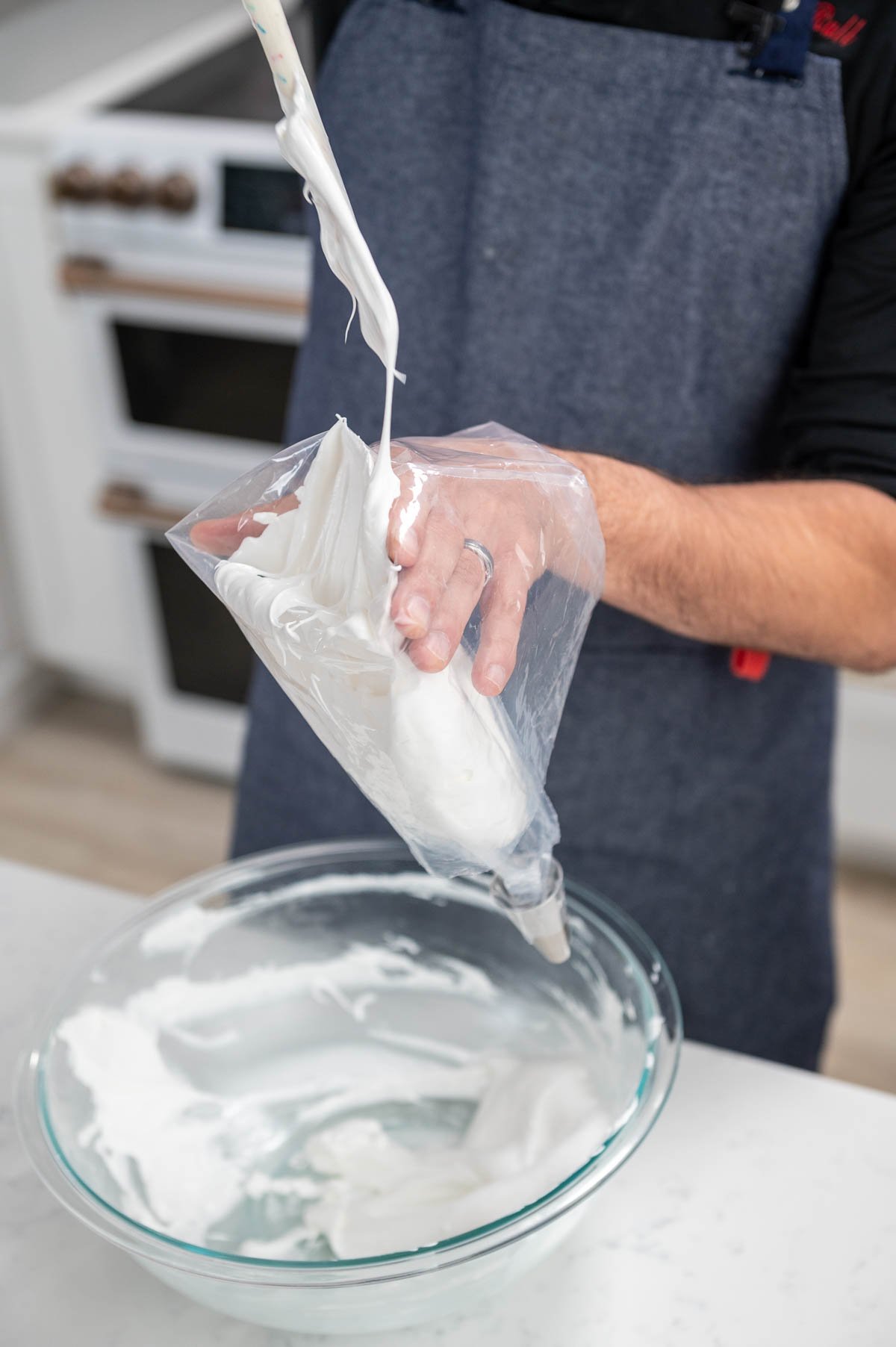 hand shown filling a piping bag with cream
