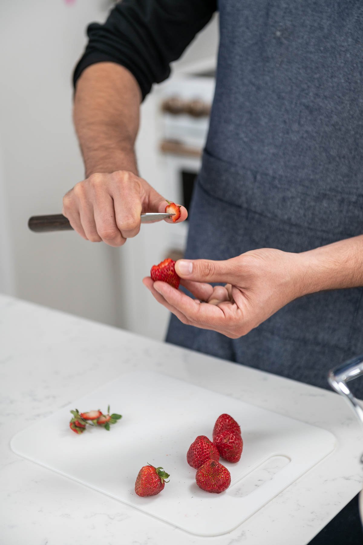 hand shown cutting a strawberry