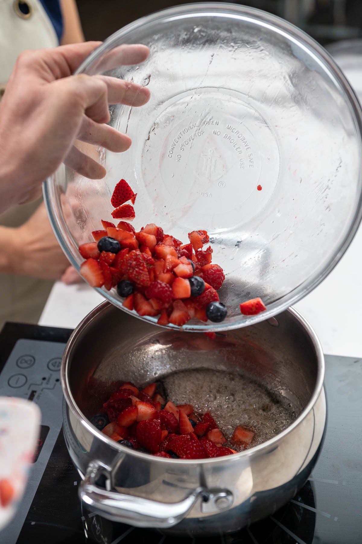 pouring fresh berries into a bowl