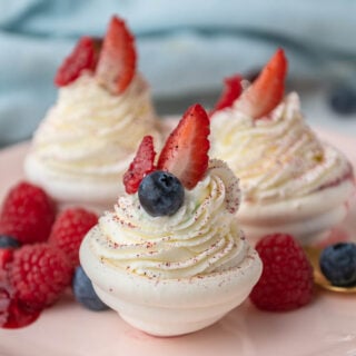 mini pavlova decorated with Chantilly cream and topped with fresh berries