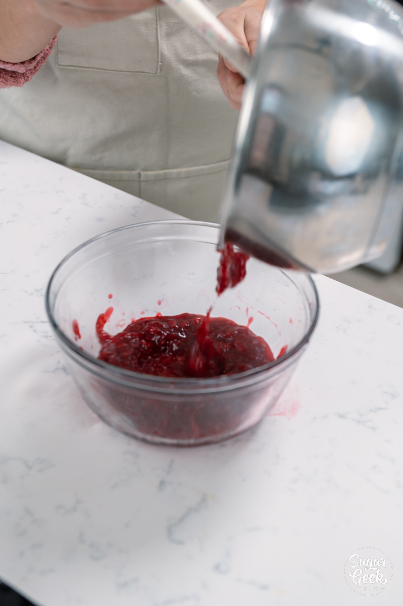 adding raspberry mixture to a clear bowl