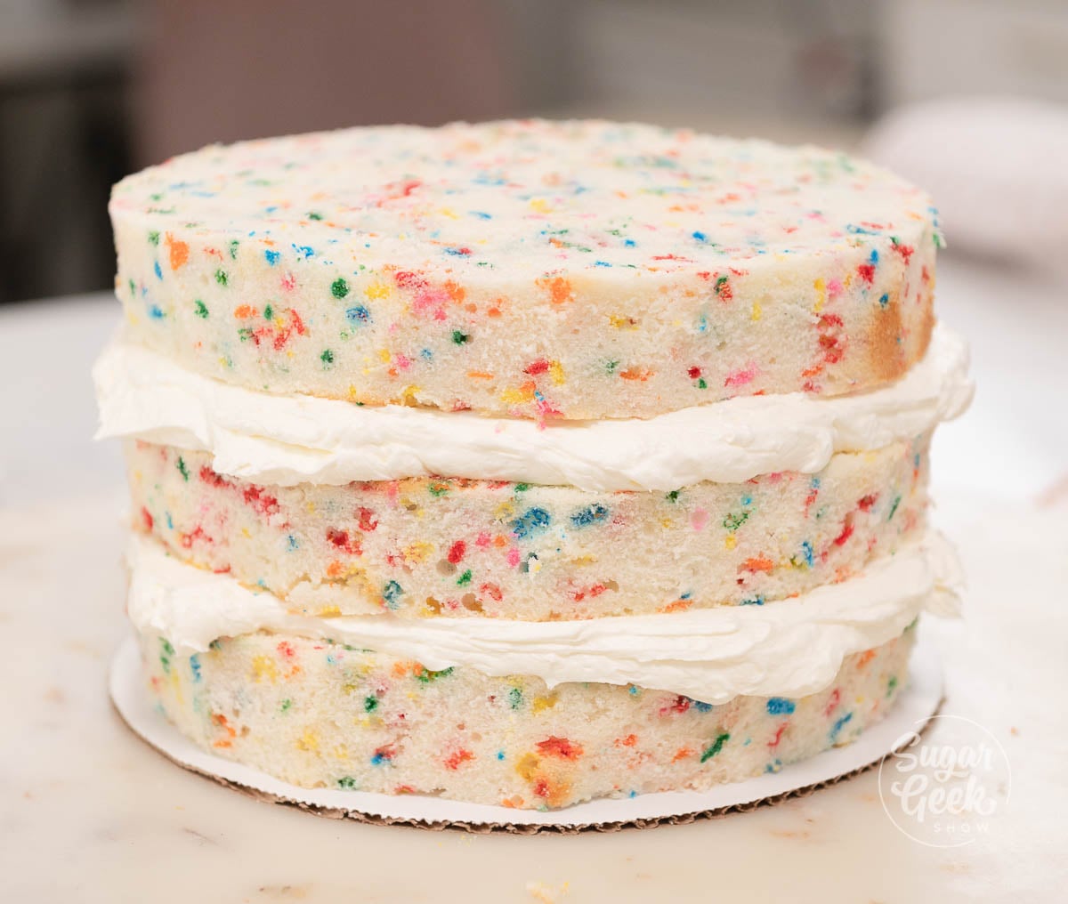 Stacked cake layers with buttercream filling between each layer