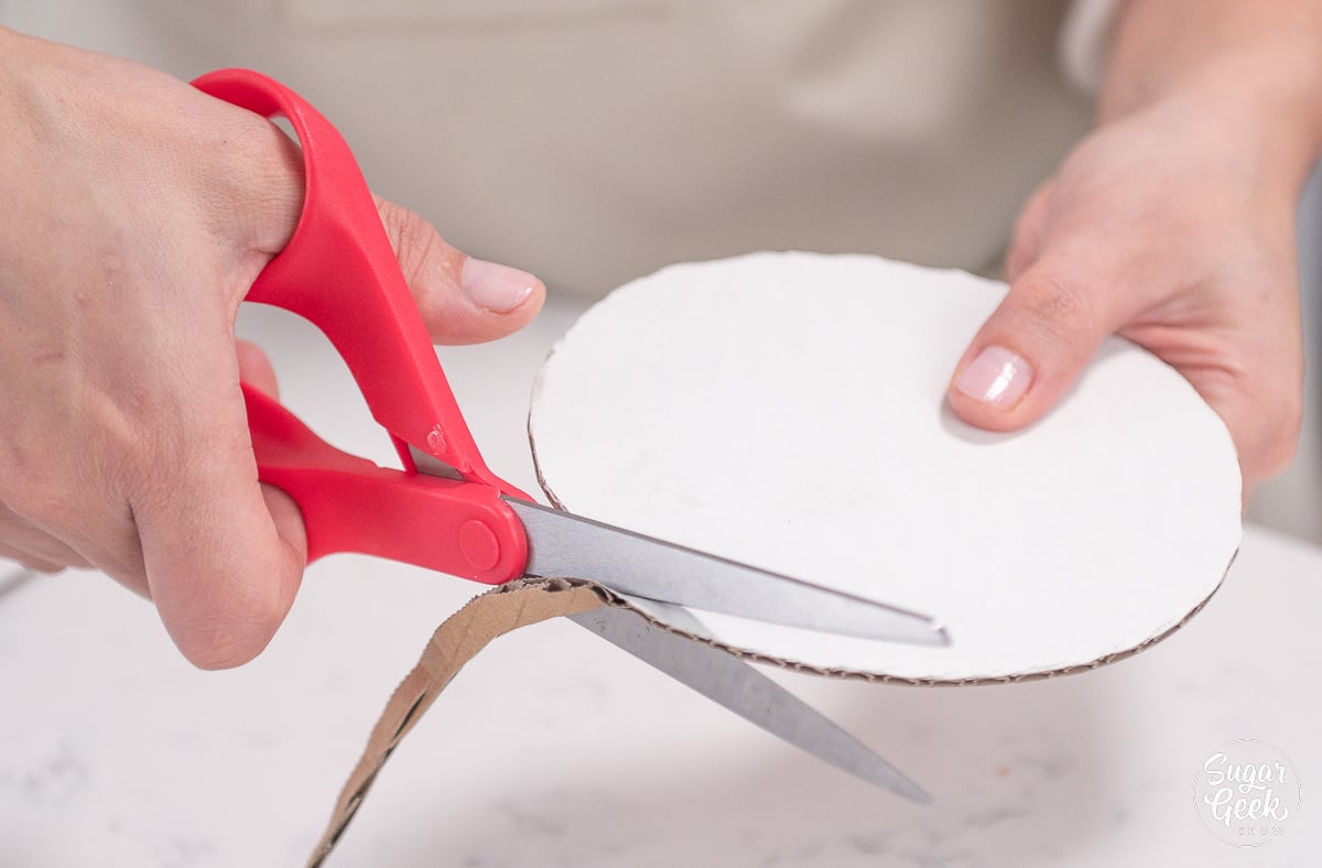trimming cake board with scissors