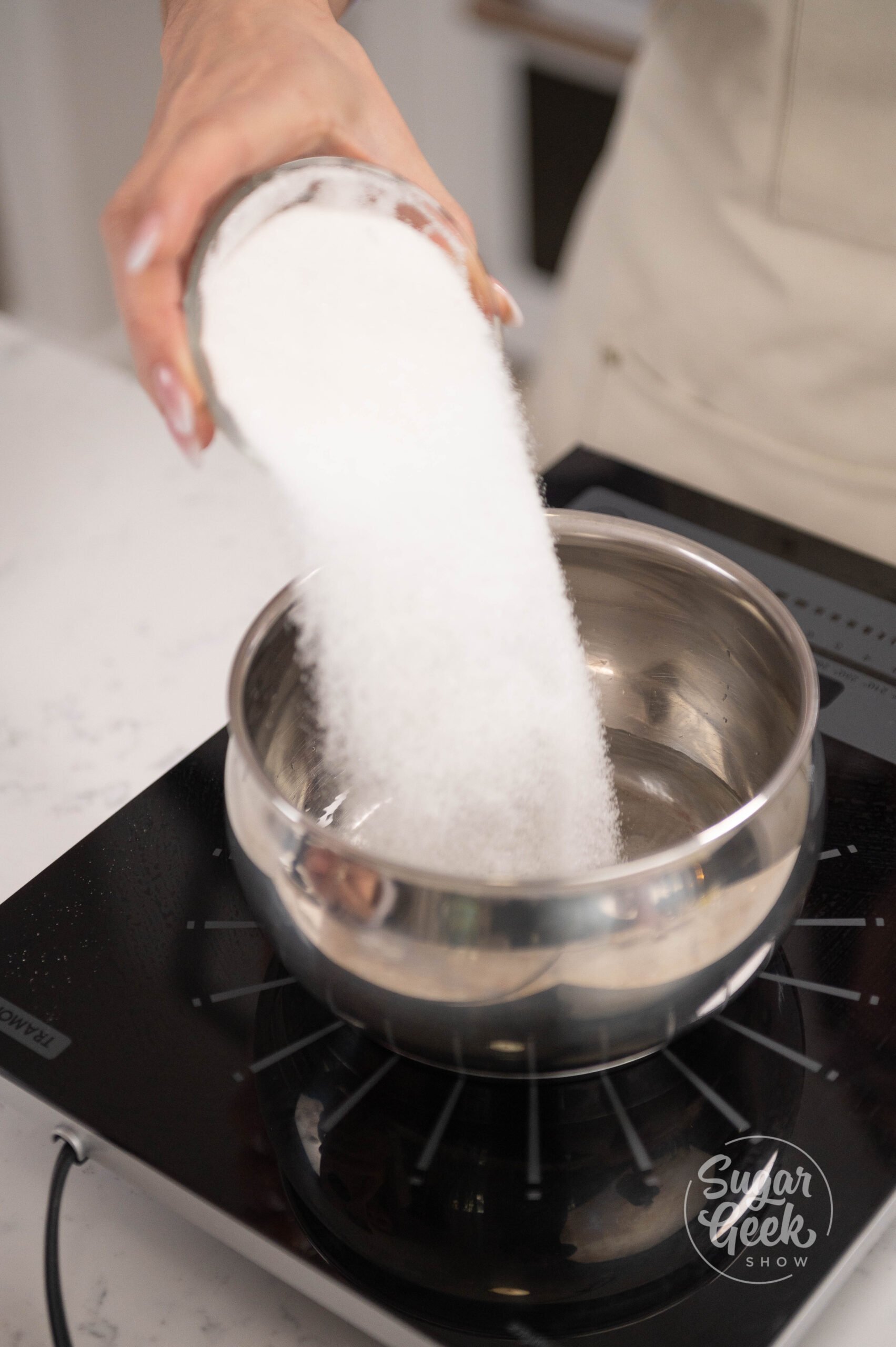 hand pouring sugar into pot