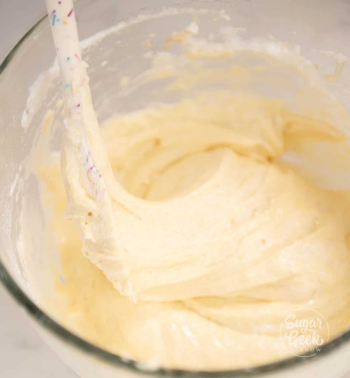Spatula inside mixing bowl filled with batter.