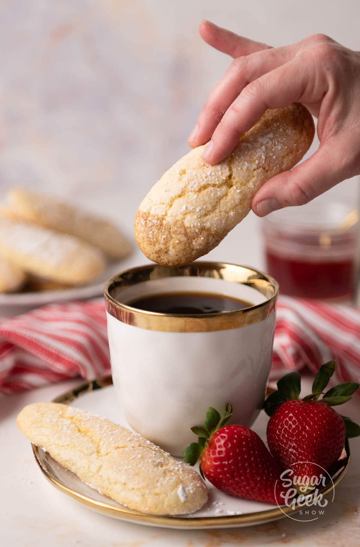hand holding cookie dipping in cup of coffee. 