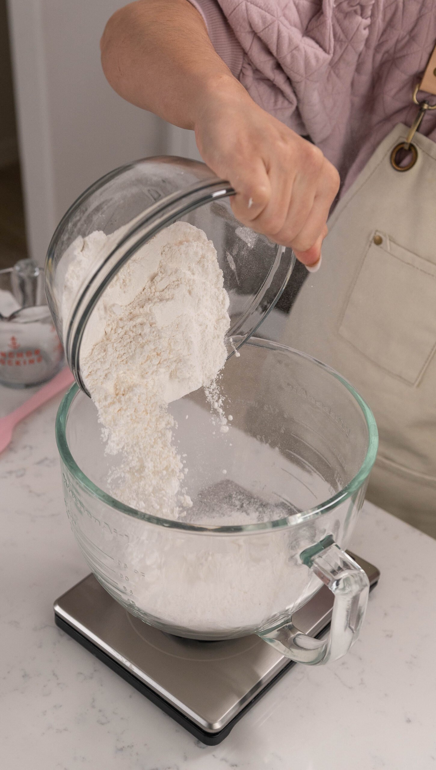 hand pouring bowl of flour into bowl