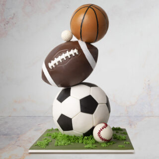 cake sculpted to look like a football, soccer ball, baseball, golf ball and baseball