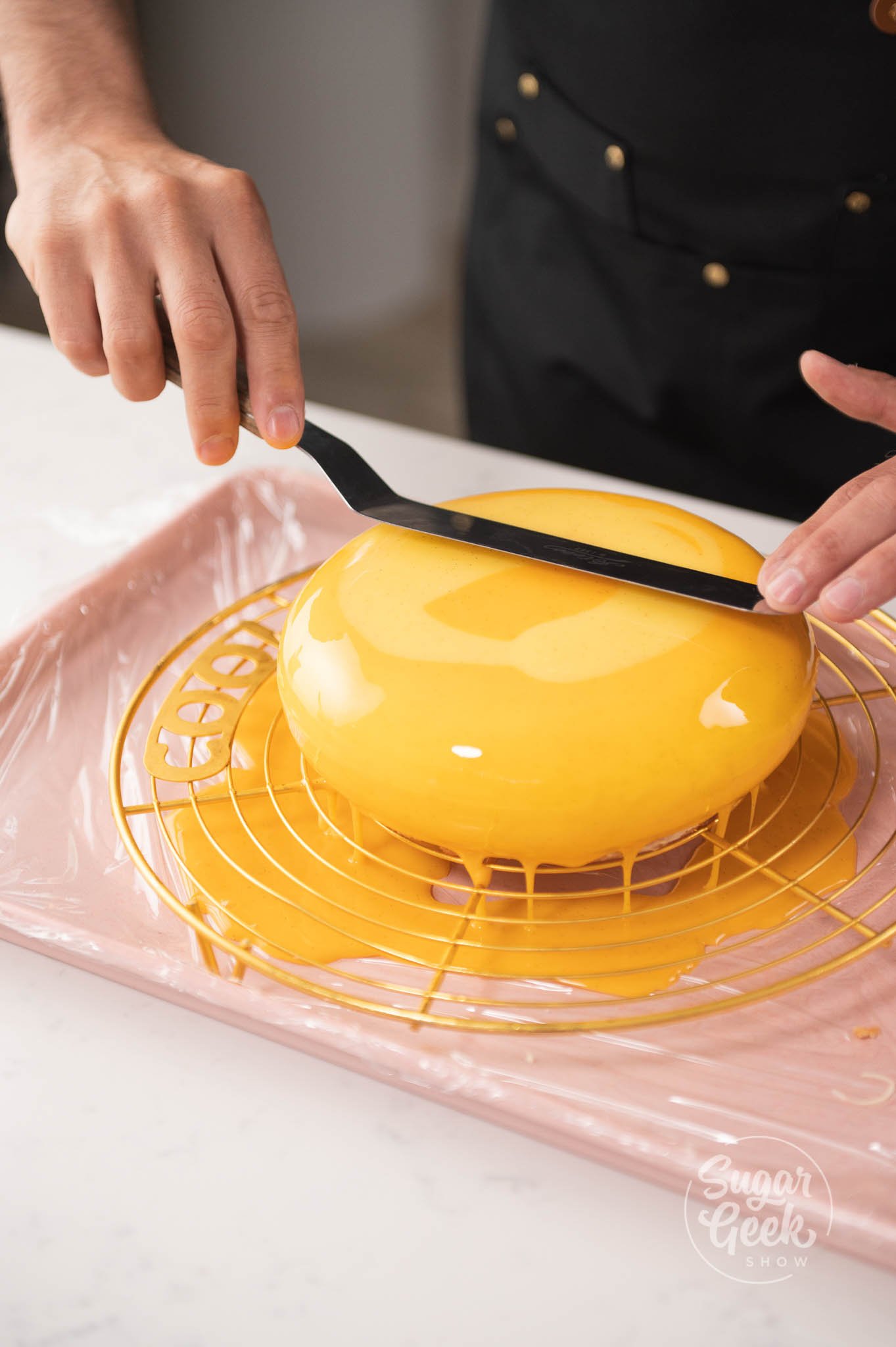 hand using spatula to smooth entremet.