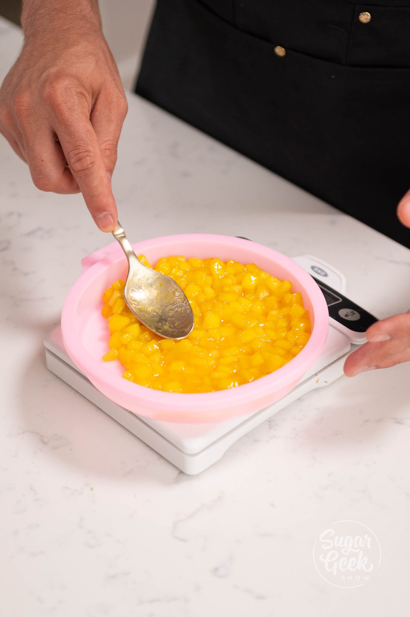 hand using spoon to spread compote in silicone mold.