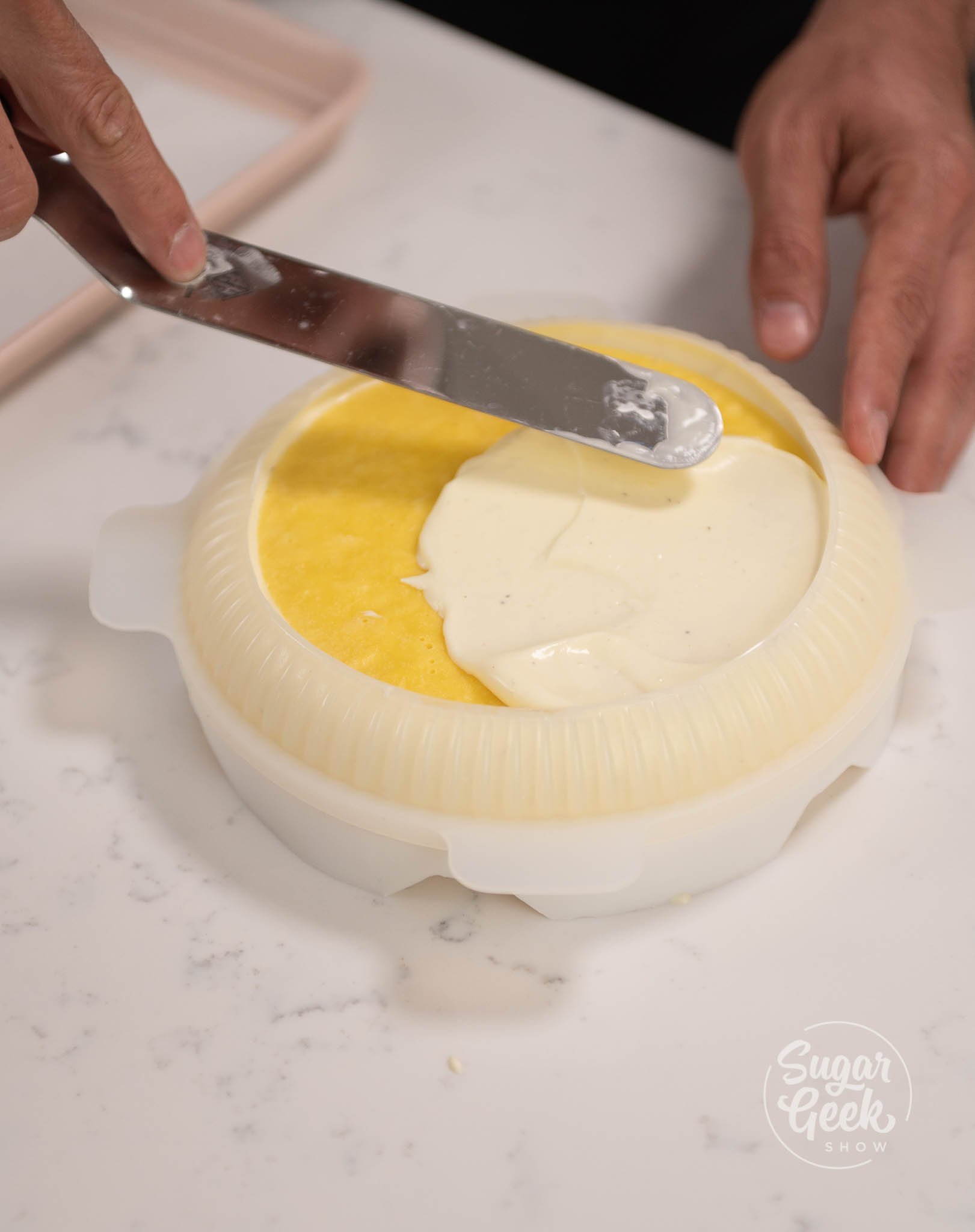 hand using spatula to spread mousse over insert.