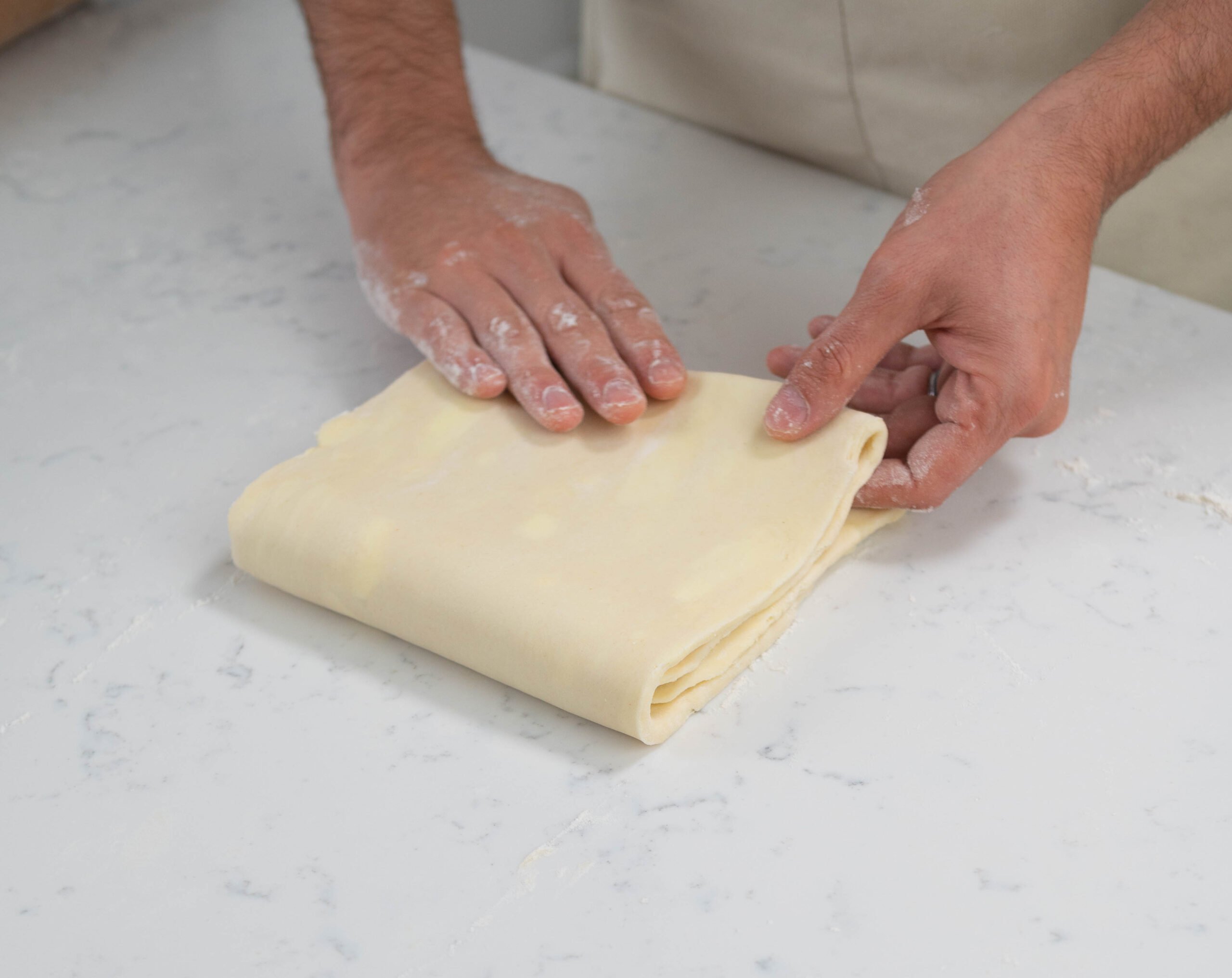 hands folding dough.