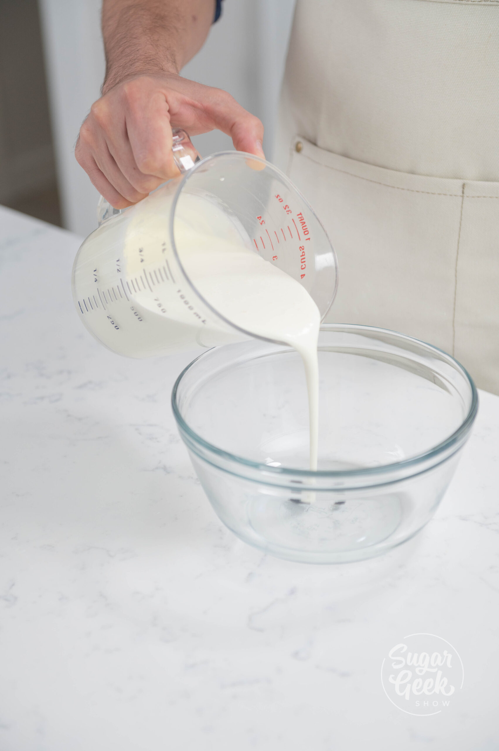 hand pouring cream into bowl wth vanilla