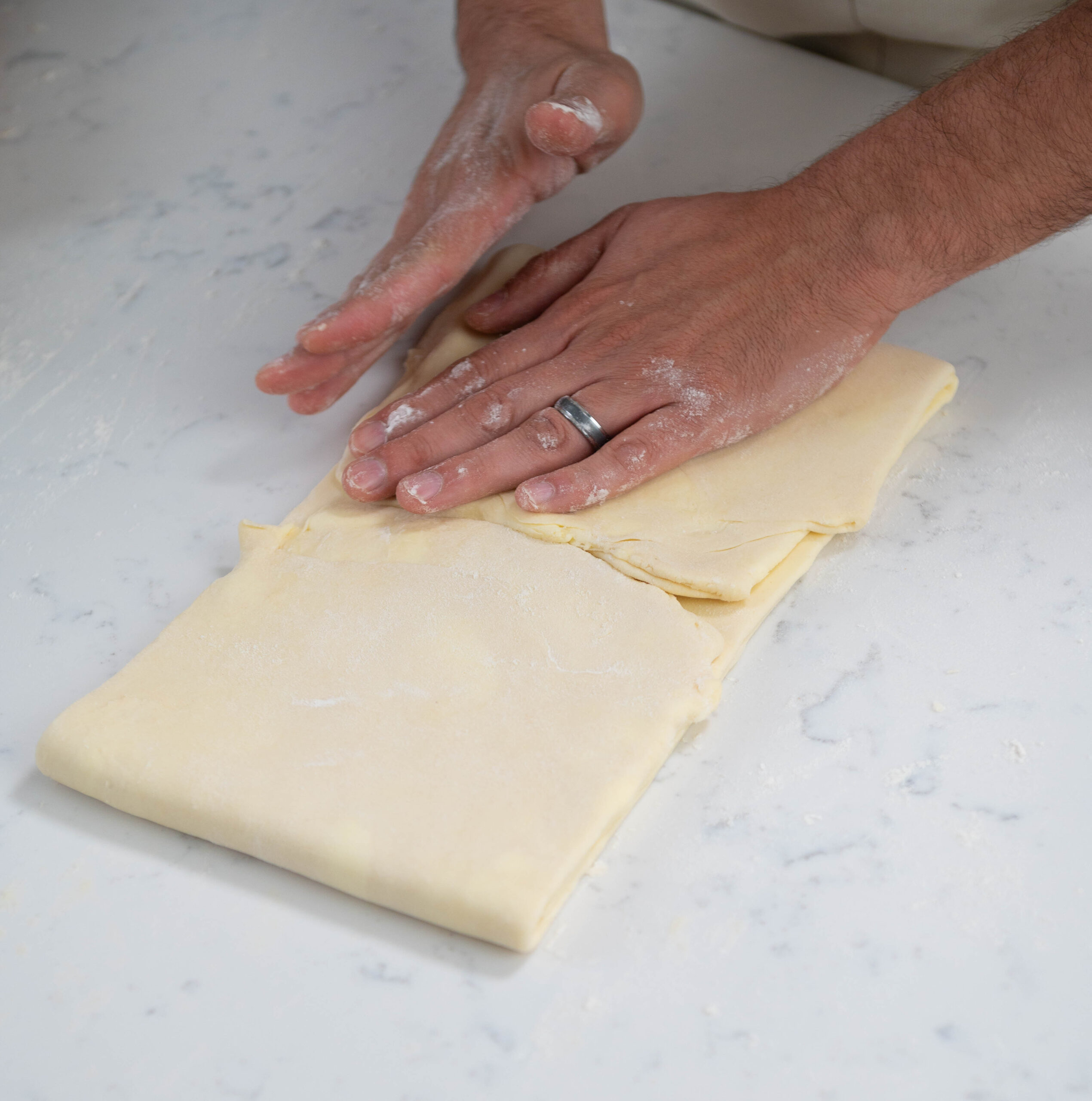hands folding dough.