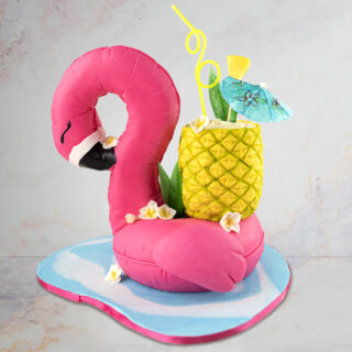 Cake sculpted to look like a flamingo pool floaty with pineapple drink