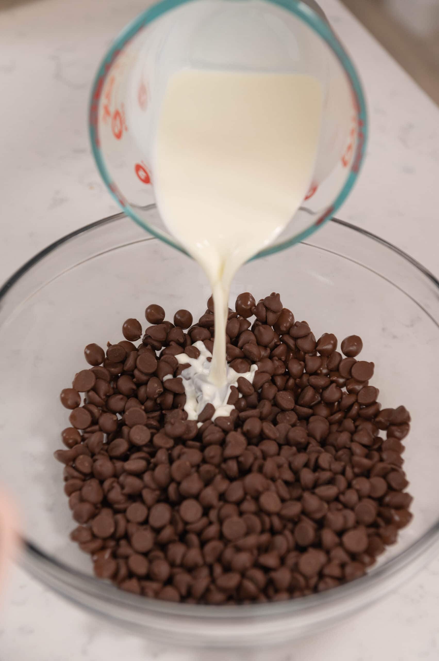 pouring hot cream onto chocolate chips